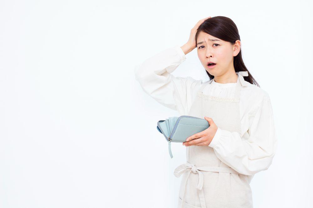 お財布の中身を見て頭を抱える女性